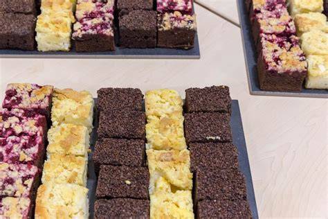 Kuchenstücke nebeneinander auf einem Buffet serviert