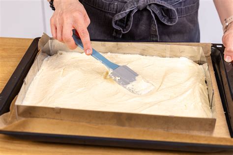 Kuchenteig auf Backblech ausgebreitet