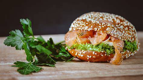 Lachs Bagel mit Honig-Senf-Soße und Rucola angerichtet