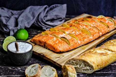 Lachs auf Planke mit Baguette und Zitronenscheiben