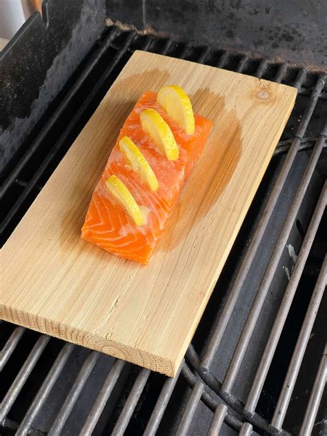 Lachsfilet auf Holzplanke im Grill, karamellisierte Kruste sichtbar