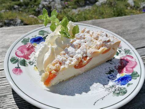 Lamsenjochhütte: Servierter Topfen-Streusel-Marillenkuchen auf Holztisch