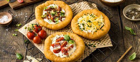 Langos mit vielfältigen Toppings: Sauerrahm und Puderzucker