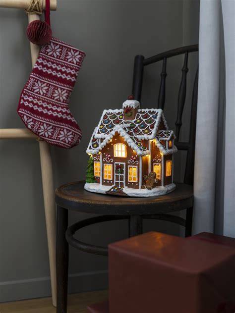 Lebkuchenhaus mit winterlicher Dekoration und Lichterkette