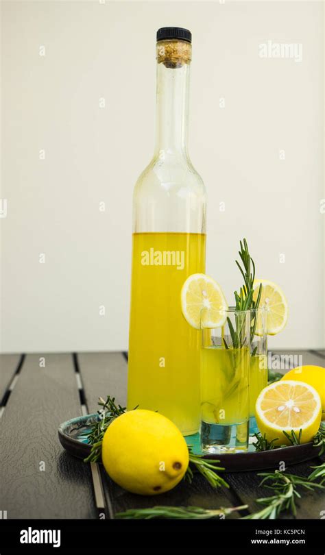 Limoncello-Fläschchen und Zitronen auf Holztisch
