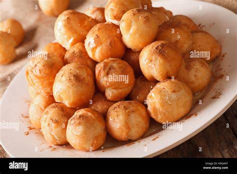 Loukoumades auf einer Platte, mit Honig und Zimt garniert