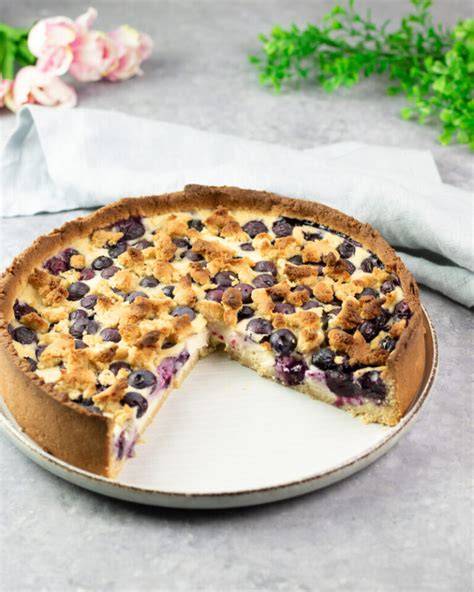 Low Carb Heidelbeer Quark Kuchen angeschnitten und mit frischen Heidelbeeren garniert