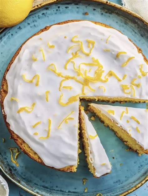 Low Carb Zitronenkuchen mit Limoncello auf einer weißen Tortenplatte