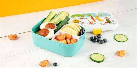 Lunchbox mit Apfel-Erdnussbutter-Ringen, Gurkensticks und gefülltem Ei (Bento-Layout)