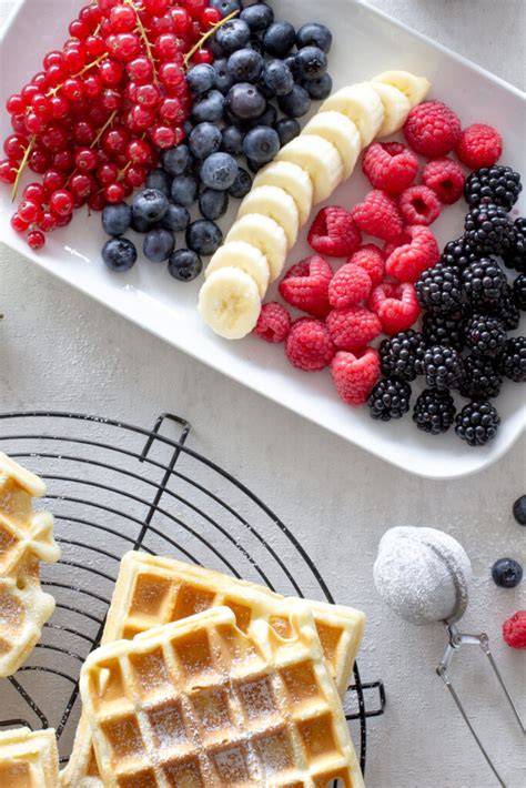 Mögliche Toppings für frisch gebackene Waffeln: Beeren, Kompott, Puderzucker, Eis