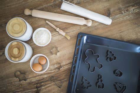 Mürbeteigkekse auf dem Backblech, Teigrolle, Ausstechformen und Margarine