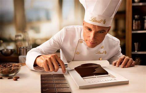 Maître Chocolatier bei der sorgfältigen Verarbeitung von Lindt Schokolade