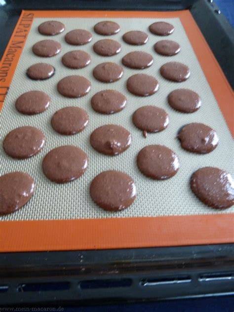 Macaron-Schablone und gespritzte Macaron-Tupfen auf Backblech
