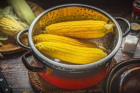 Maiskolben im Topf mit Butter und Gewürzen