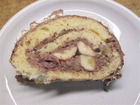 Makro: Anschnitt der dunklen Biskuitrolle mit cremiger Schokosahne