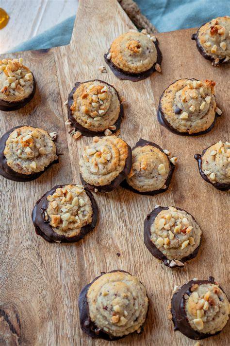 Makronen mit Marzipan, Walnüssen und Schokoladenglasur auf einem weihnachtlichen Teller