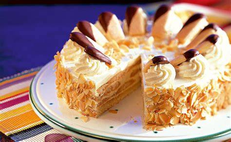 Malakofftorte klassisch dekoriert mit Mandelsplittern und Sahnetuffs