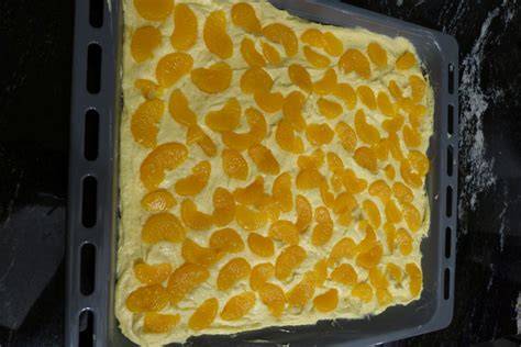 Mandarinen auf dem Teig vor dem Backen