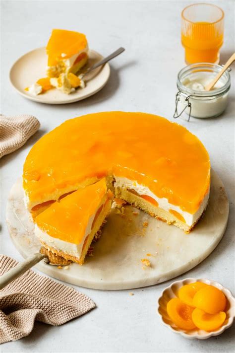 Mandarinen-Mascarpone-Torte angeschnitten auf weißer Tortenplatte