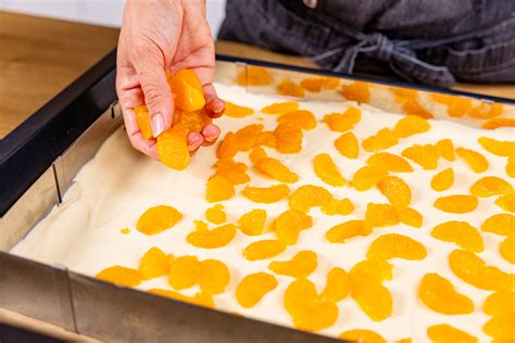 Mandarinen-Schmand-Creme wird auf dem Kuchen verteilt