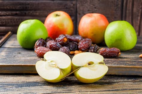Mandeln, Pflaumen und Äpfel auf Holzbrett