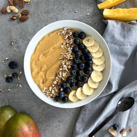 Mango und gefrorene Bananenscheiben auf Holzbrett