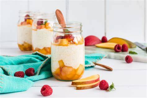 Mango-Pfirsich-Kompott neben cremigem Milchreis in Gläsern