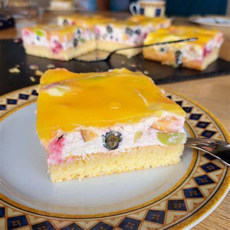Mango-Quark-Sahne-Torte mit Mangopüree und Früchten dekoriert