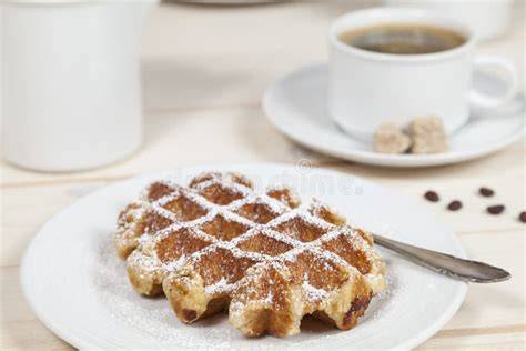 Manner Neapolitaner Waffel neben einer Tasse Kaffee und Likörglas