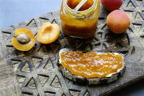 Marillenmarmelade auf einem Brot mit frischen Marillen