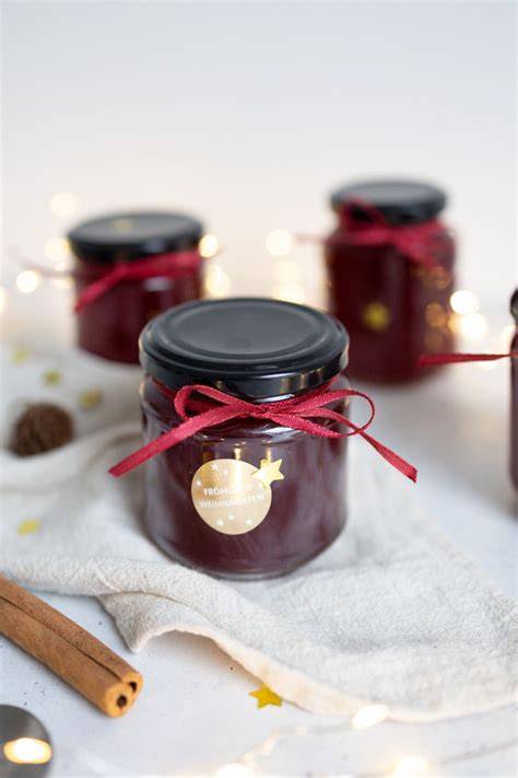 Marmeladengläser mit weihnachtlicher Dekoration als Geschenk