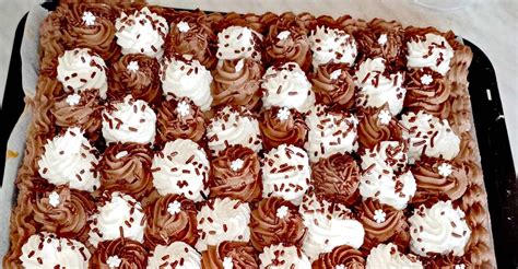 Marmorkuchen-Scheiben mit Puderzucker, dazu Schlagsahne und Kaffee auf weißer Spitzentischdecke