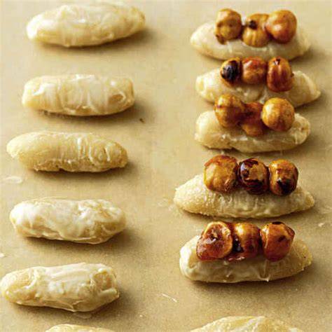 Marzipan und Haselnüsse auf Holzbrett