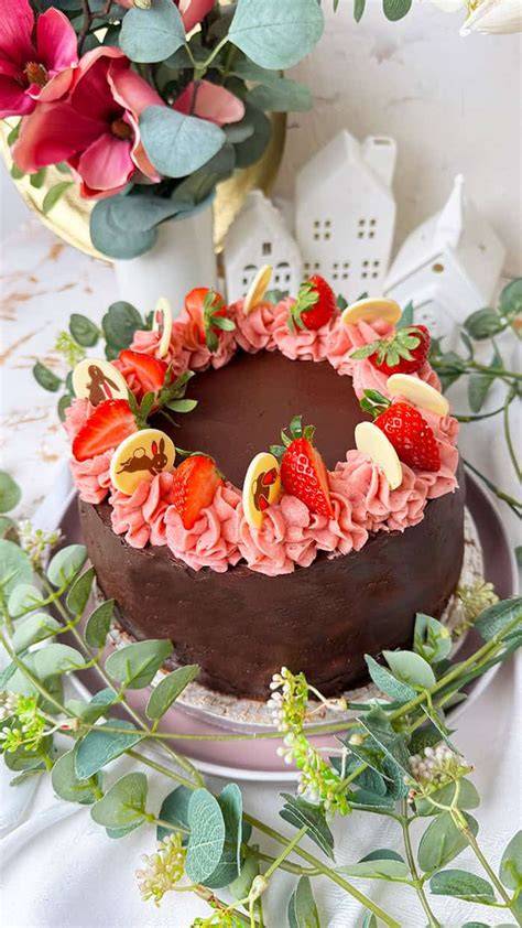 Marzipan-Biskuit-Torte, angeschnitten, mit Deko und Zutaten