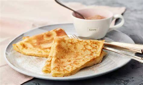 Marzipan-Crêpes auf Teller mit Orangen-Soße