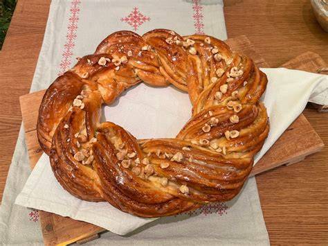 Marzipan-Hefekranz auf Holzbrett, aufgeschnitten, mit Glasur und Mandeln