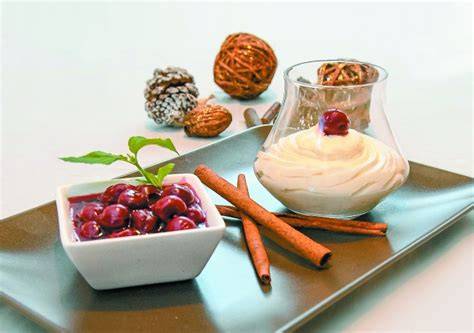 Marzipanmousse auf Zimtkirschen - angerichtet im Dessertglas mit Pistazien und Orangenspirale