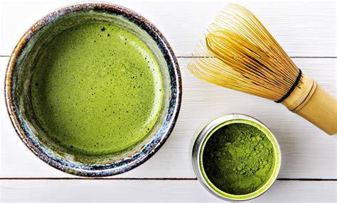 Matcha Pulver in Schale mit Bambusbesen