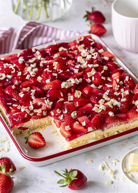 Mehrere Blechkuchen-Scheiben mit weißer Schokolade, Vanillepudding und Beeren