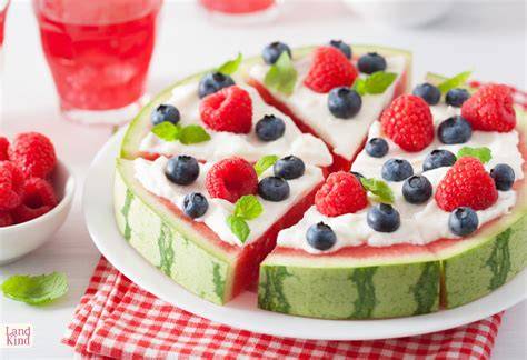 Mehrstöckige Wassermelonentorte auf Tortenteller, dekoriert mit Beeren und Obst