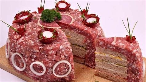 Mett Torte auf dekorierter Tortenplatte, mit Frischkäse ummantelt und Kräutern verziert