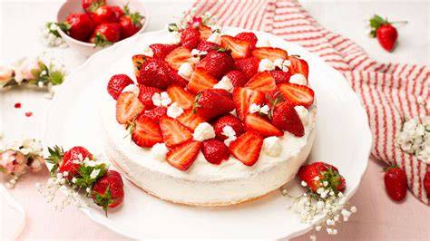 Midsommar-Tisch mit Erdbeertorte und traditionellen Speisen