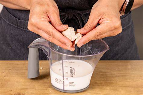 Milch, Hefe und Zucker in einer Schüssel als Basis für Pickert-Teig