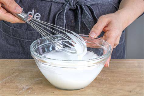 Milch und Puderzucker in Schüssel