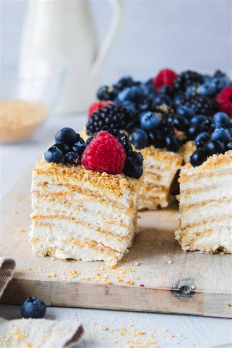 Milchmädchen‑Torte mit Beeren und Krokant garniert