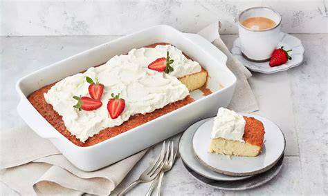 Milchmischung und vorbereiteter Tres Leches Kuchen in der Backform