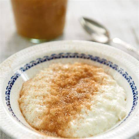 Milchreis im Topf mit Vanilleschote und Zimtstange