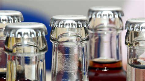 Mini-Schokoküsse mit angeklebten Kronkorken als Flaschenhälse