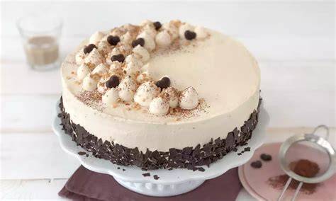 Mini-Schokotorte auf Tortenplatte, angerichtet mit Schokoraspeln und Sahnetupfen