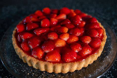 Mit rotem Tortenguss überzogener Erdbeerkuchen mit Schokoraspeln